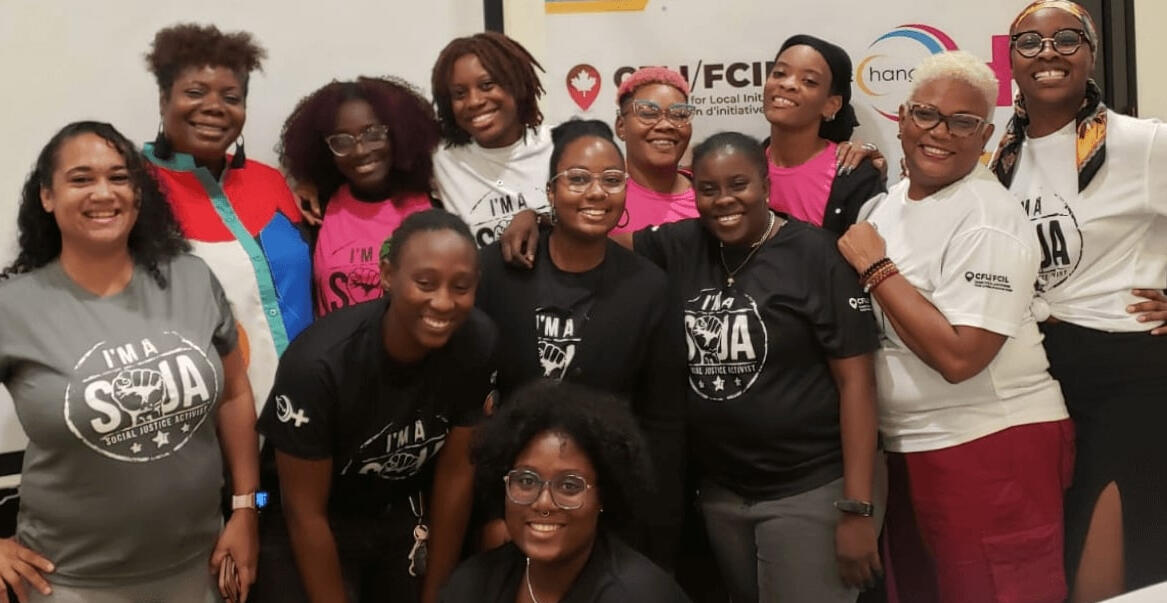 group image of women smiling at the camera with some hanging their arm over each other's shoulders.